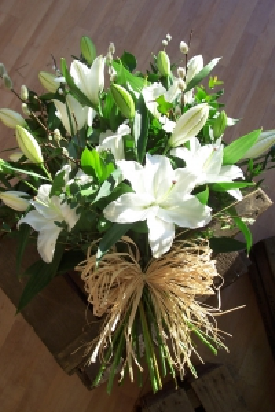 Tied Sheaf with lilies - A very natural funeral tribute. The flowers are arranged in the hand and tied with a natural raffia bow. Please specify if you would like us to include a particular flower or colour.