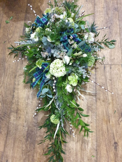 Spray with personal detail - This is an example of a foliage based natural and personal single ended spray.  In this instance the family added their own tartan and thistles for a Scottish style but other items could be added such as garden foliage and flowers or materials personal to the family member(s)