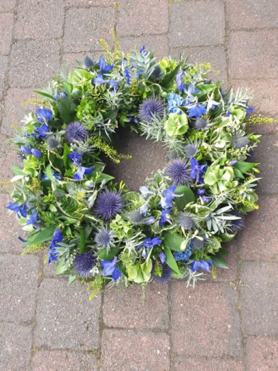 Blue and green thistle wreath - A natural wreath with plenty of textured foliage small blue flowers and eryngium thistles.  Can be biodegradable or in white and green.