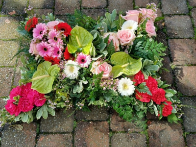 Mixed pillow - A natural pillow arrangement based with mixed foliage and moss and grouped flowers in pinks, reds, white and green.